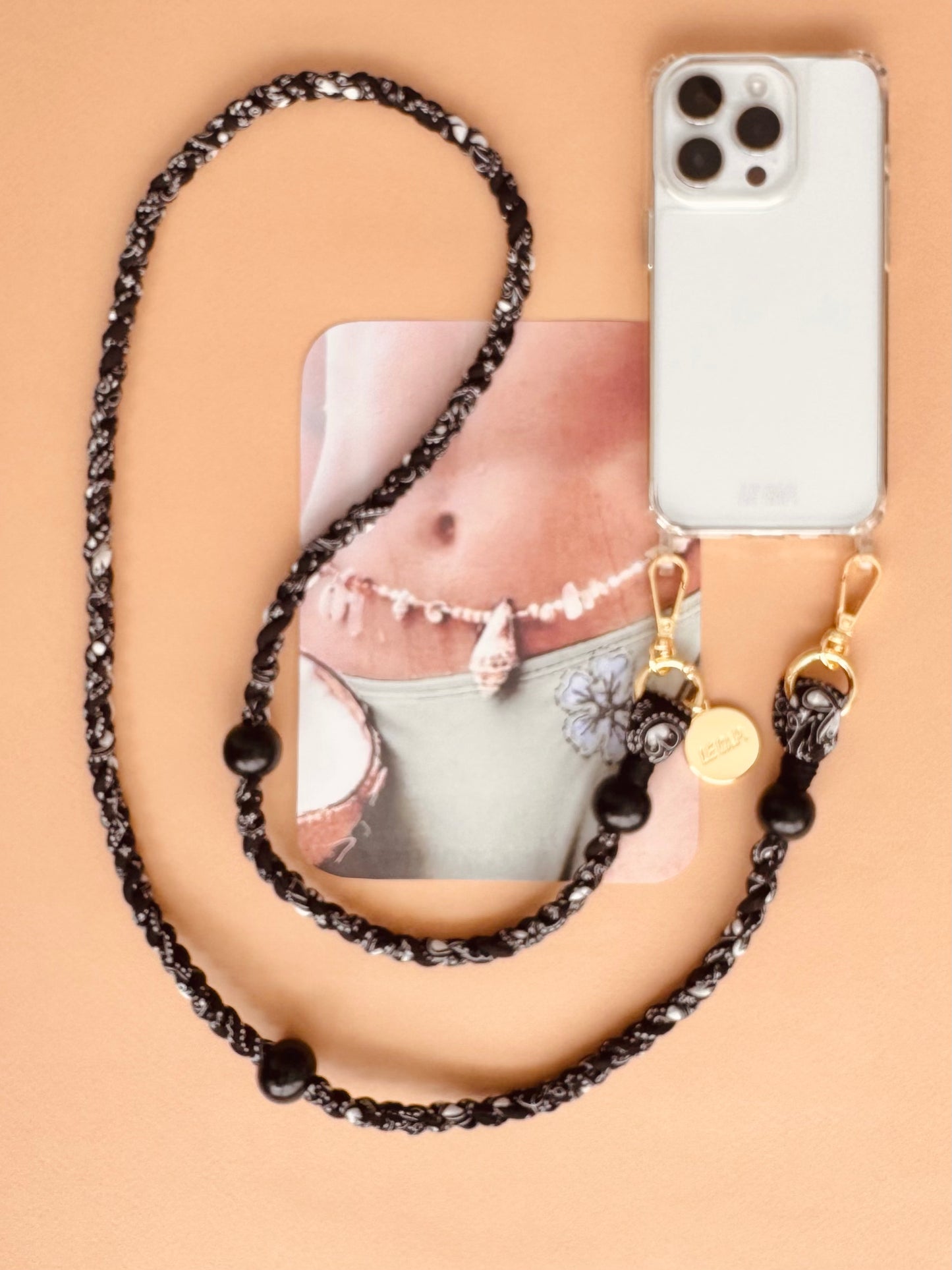 Le Cap black bandana crossbody phone strap on a beige surface